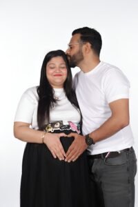 Family maternity studio shoot in Faridabad – Alok Color Lab professional pregnancy photography with partner and kids in elegant indoor setup.