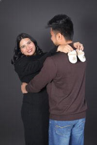 Pregnant couple posing gracefully during a maternity photoshoot captured by Alok Color Lab